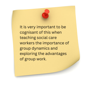 The image shows a yellow sticky note pinned with a red pushpin. The note contains a typed message about the importance of group dynamics in social care education. The text reads: "It is very important to be cognisant of this when teaching social care workers the importance of group dynamics and exploring the advantages of group work."